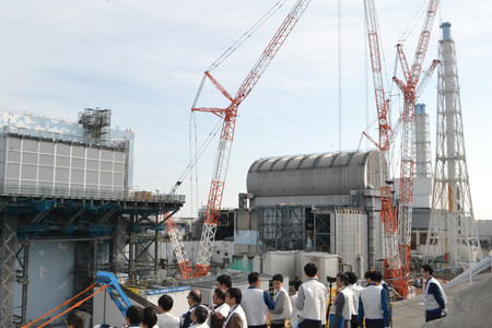 東京電力福島第1原発構内の高台から取材する報道陣。左側が2号機、丸い屋根が3号機=1月30日午後(代表撮影)