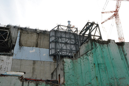 津波の痕跡が残る東京電力福島第1原発3号機の外壁。緑色に見えるのは放射性物質の飛散防止剤=1月30日午後(代表撮影)