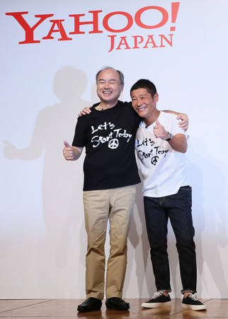 肩を組むZOZO創業者の前沢友作氏(右)とソフトバンクグループの孫正義会長兼社長=12日午後、東京都目黒区