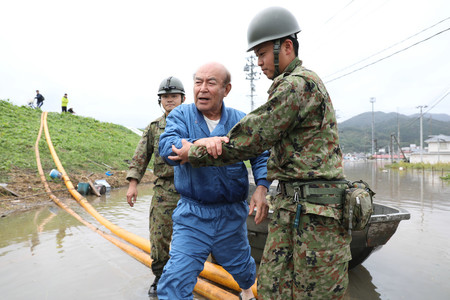 自衛隊員に救助される男性=14日午前、宮城県丸森町