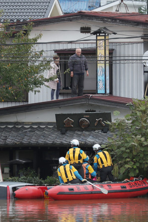 ボートで救助活動する警察官=14日午後、宮城県丸森町