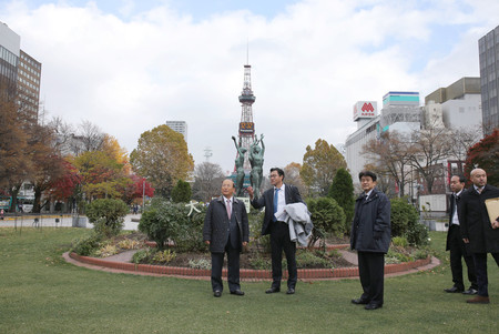 東京五輪のマラソンコースの候補地、大通公園を視察する大会組織委員会の武藤敏郎事務総長(左端)ら=8日午後、札幌市中央区