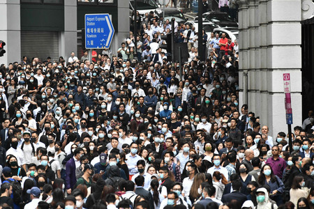 12日、香港の中環(セントラル)で、抗議デモに参加する会社員ら(AFP時事)