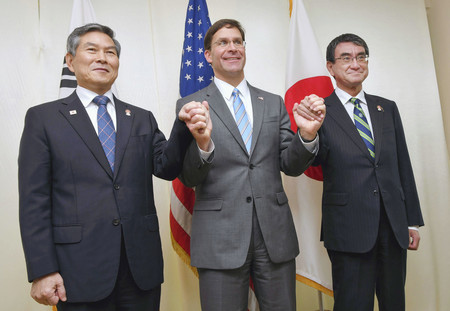 日米韓防衛相会談を前に手をつなぐ(左から)韓国の鄭景斗国防相、エスパー米国防長官、河野太郎防衛相=17日、バンコク(代表撮影)
