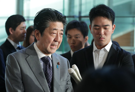 記者団の質問に答える安倍晋三首相(左)=18日午前、首相官邸
