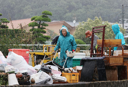 雨が強まる中、災害ごみを出す人たち。芦北町は災害廃棄物仮置き場がいっぱいになり、一時的に受け入れを停止している=9日午後、熊本県同町