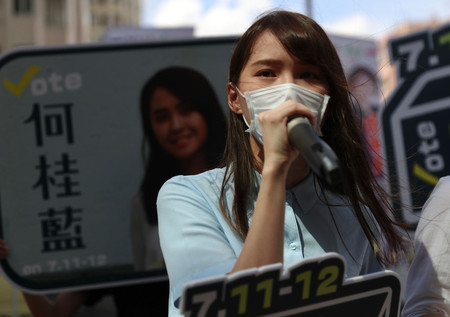 民主派が実施した予備選挙の選挙活動で、応援演説を行う活動家の周庭氏=11日、香港(AFP時事)