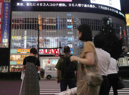 東京・新宿駅前で帰宅の途につく人たち。東京都は新たに463人の新型コロナウイルス感染者が確認されたと発表した=31日午後、東京都新宿区