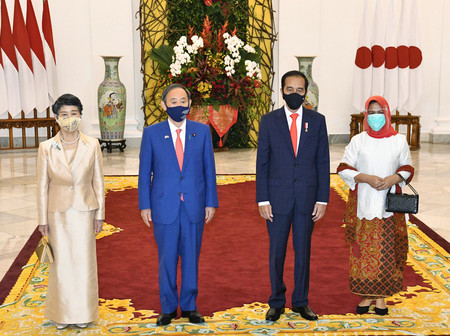 大統領宮殿のエントランスで記念撮影をする菅義偉首相(中央左)と真理子夫人(左)、インドネシアのジョコ大統領(同右)とイリアナ夫人=20日午後、インドネシア・ボゴール市(代表撮影)