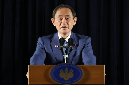 内外記者会見に臨む菅義偉首相=21日午前、ジャカルタ