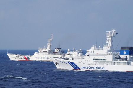 中国海警局の船(奥)を監視する海上保安庁の巡視船=撮影日不明、沖縄県・尖閣諸島近海(海上保安庁提供)
