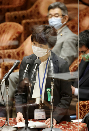 衆院予算委員会で答弁する山田真貴子内閣広報官。後方は武田良太総務相=25日午前、国会内