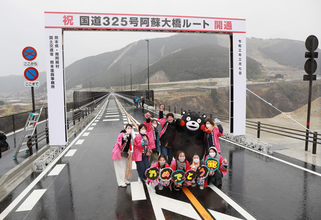 新阿蘇大橋の開通を祝うくまモンと地元の人々=7日午後、熊本県南阿蘇村