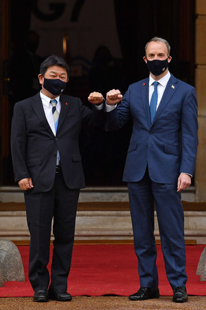 4日、ロンドンで、茂木敏充外相(左)を迎えるラーブ英外相(AFP時事)