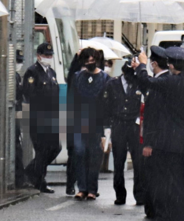 公記号偽造容疑での逮捕を前に、埼玉県警から茨城県警に移送される岡庭由征容疑者(中央)=2月15日、埼玉県三郷市(写真の一部に画像処理をしています)