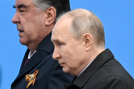 9日、モスクワで、タジキスタンのラフモン大統領(左)と「赤の広場」に立つロシアのプーチン大統領(AFP時事)