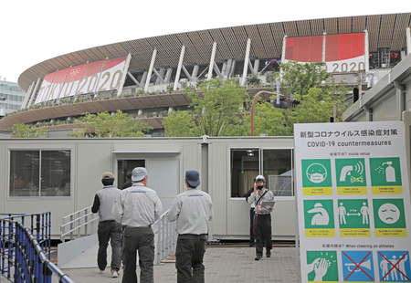 五輪開幕を控え、感染症対策の準備が行われる国立競技場前=15日、東京都新宿区