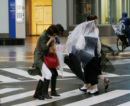台風14号が接近した福岡市の繁華街・天神地区を歩く人たち=17日午後、同市中央区