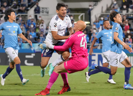 後半、激突する横浜Mのレオセアラ(中央左)と横浜CのGKブローダーセン(同右)=25日、ニッパツ