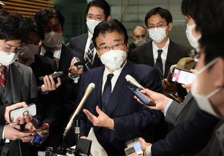 オミクロン株の国内初確認を受け、記者団の質問に答える後藤茂之厚生労働相(中央)=30日午後、首相官邸