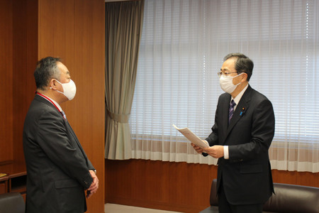 統計書き換え問題で検証委員会の寺脇一峰委員長(左)から報告書を受け取る斉藤鉄夫国土交通相=14日午前、東京都千代田区