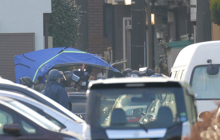 民家に立てこもった男の身柄を確保した警察官ら=28日午前8時2分、埼玉県ふじみ野市
