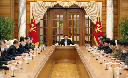 12日、平壌で開かれた朝鮮労働党政治局の会議に出席する北朝鮮の金正恩総書記(中央、朝鮮中央通信提供)(AFP時事)
