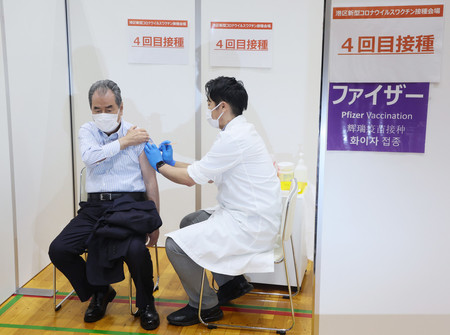 新型コロナウイルスワクチンの４回目接種を受ける人＝２５日午前、東京都港区