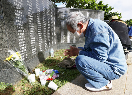 沖縄戦で祖母らを亡くし、「平和の礎（いしじ）」で手を合わせる山城強さん＝２３日午前、沖縄県糸満市の平和祈念公園