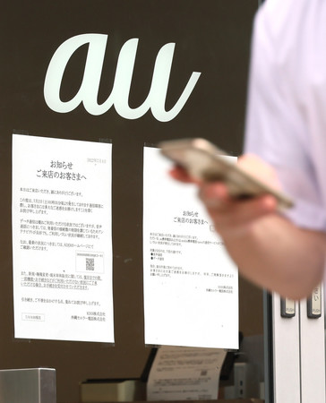 auショップに貼られた通信障害のお知らせ=4日午後、東京都千代田区