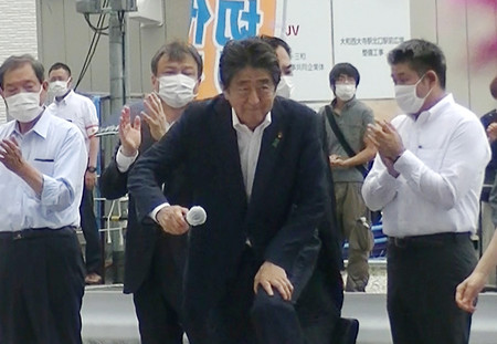 演説に臨む自民党の安倍晋三元首相(手前)。右奥は発砲したとみられる山上徹也容疑者=8日、奈良市(目撃者提供)