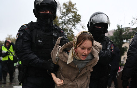 24日、モスクワで、部分動員令に反対して警察に拘束される女性(AFP時事)