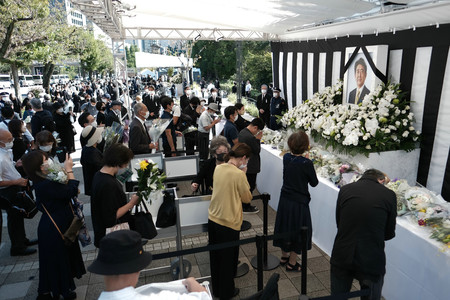 安倍晋三元首相の国葬が行われる日本武道館近くに設けられた献花台を訪れ、花を手向ける人たち=27日午前、東京都千代田区の九段坂公園(代表撮影)
