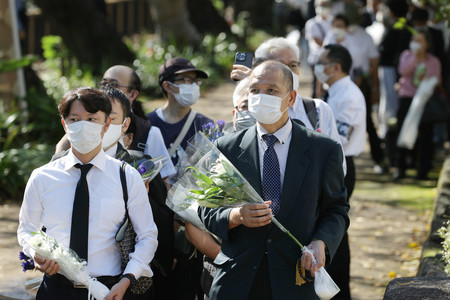安倍晋三元首相を悼み、献花の列に並ぶ人たち=27日午前、東京都千代田区(代表撮影)