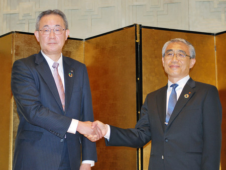 経営統合に基本合意し、握手する八十二銀行の松下正樹頭取(左)と長野銀行の西沢仁志頭取=28日午後、長野市