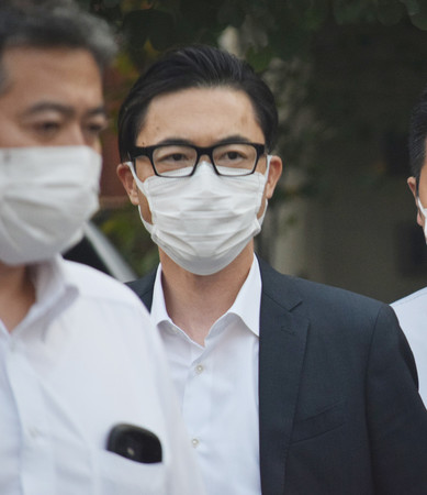 捜査員と共に自宅を出るカッパ・クリエイト社長の田辺公己容疑者=30日午後、神奈川県藤沢市