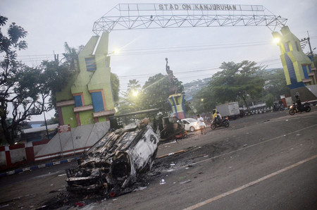 ２日、暴動から一夜明けたインドネシア東ジャワ州マランのサッカー場前に残された、放火された車（ＡＦＰ時事）