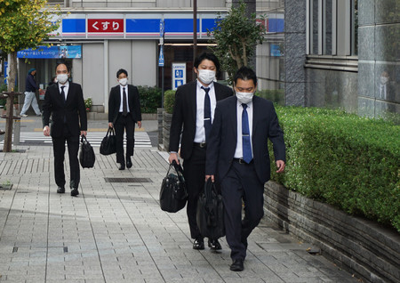 「電通ライブ」本社が入居するビルに家宅捜索に入る東京地検の係官ら=29日午前、東京都千代田区