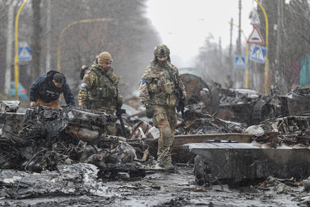破壊されたロシア軍の装備を調べるウクライナ兵=4月3日、北部キーウ州ブチャ(EPA時事)