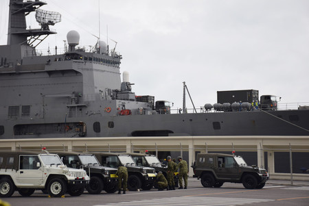 石垣港に入った海上自衛隊の輸送艦「おおすみ」から降ろされる陸上自衛隊の車両=18日午前、沖縄県石垣市