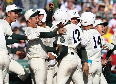 タイブレークの末に東邦に勝利し、サヨナラ打の西村(12番)を祝福する報徳学園ナイン=28日、甲子園