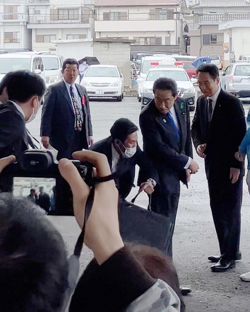 筒状の物体が投げ込まれ、振り返る岸田文雄首相(右から2人目)=15日午前、和歌山市(目撃者提供)