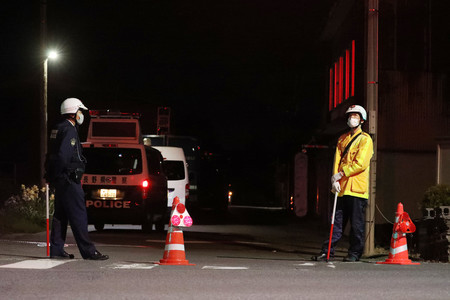立てこもり現場付近で警戒する警察官=25日午後10時21分、長野県中野市江部