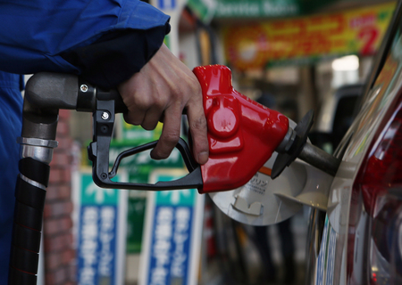 ガソリンスタンドで給油する店員(資料)