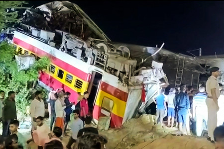 2日、インド東部オディシャ州バラソール地区で起きた列車衝突事故で転覆した車両(現場を撮影した動画より)(AFP時事)
