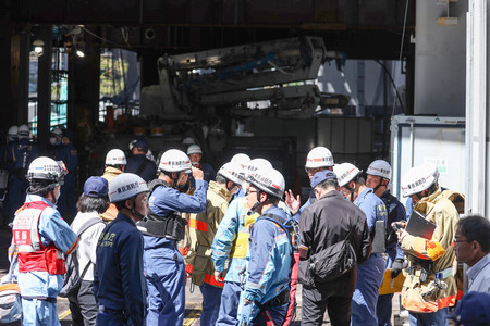 鉄骨が倒れたビル工事現場で活動する消防隊員ら=19日午前10時31分、東京・八重洲