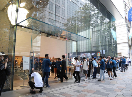 米アップルのスマートフォン「iPhone(アイフォーン)」新型モデルの「15」シリーズを購入するため店内へ入る客ら=22日午前、東京都渋谷区