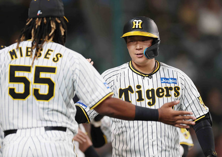 4回、先制2ランを放ち、ベンチ前で祝福される阪神の大山(右)=26日、甲子園