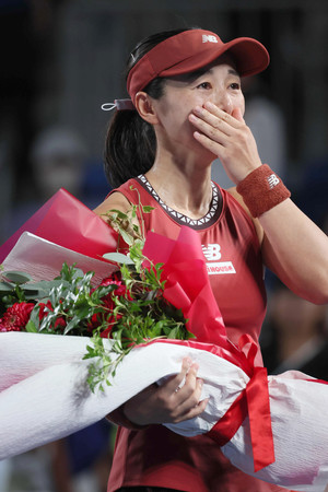 試合後、奈良くるみさんから花束を受け取り感極まる土居美咲=28日、東京・有明テニスの森公園