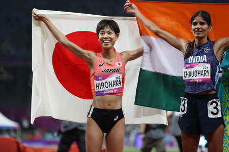 陸上女子5000メートル決勝のレースを終え、日の丸を掲げる広中璃梨佳(左)=3日、中国・杭州